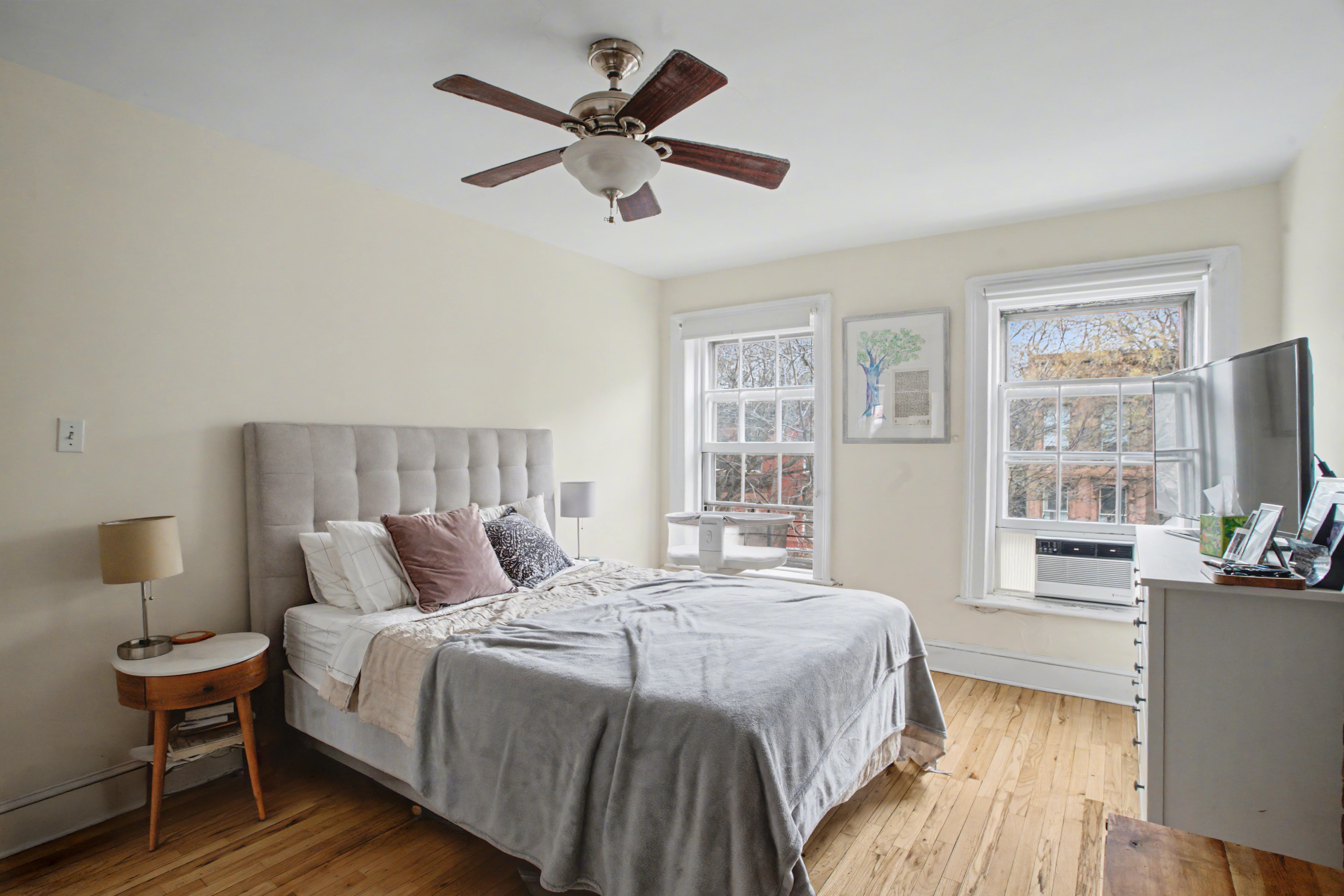 246 Cumberland Street, Unit 2 Brooklyn, NY 11205 - Photo 9 of 15 a bedroom with a large bed a chandelier and windows