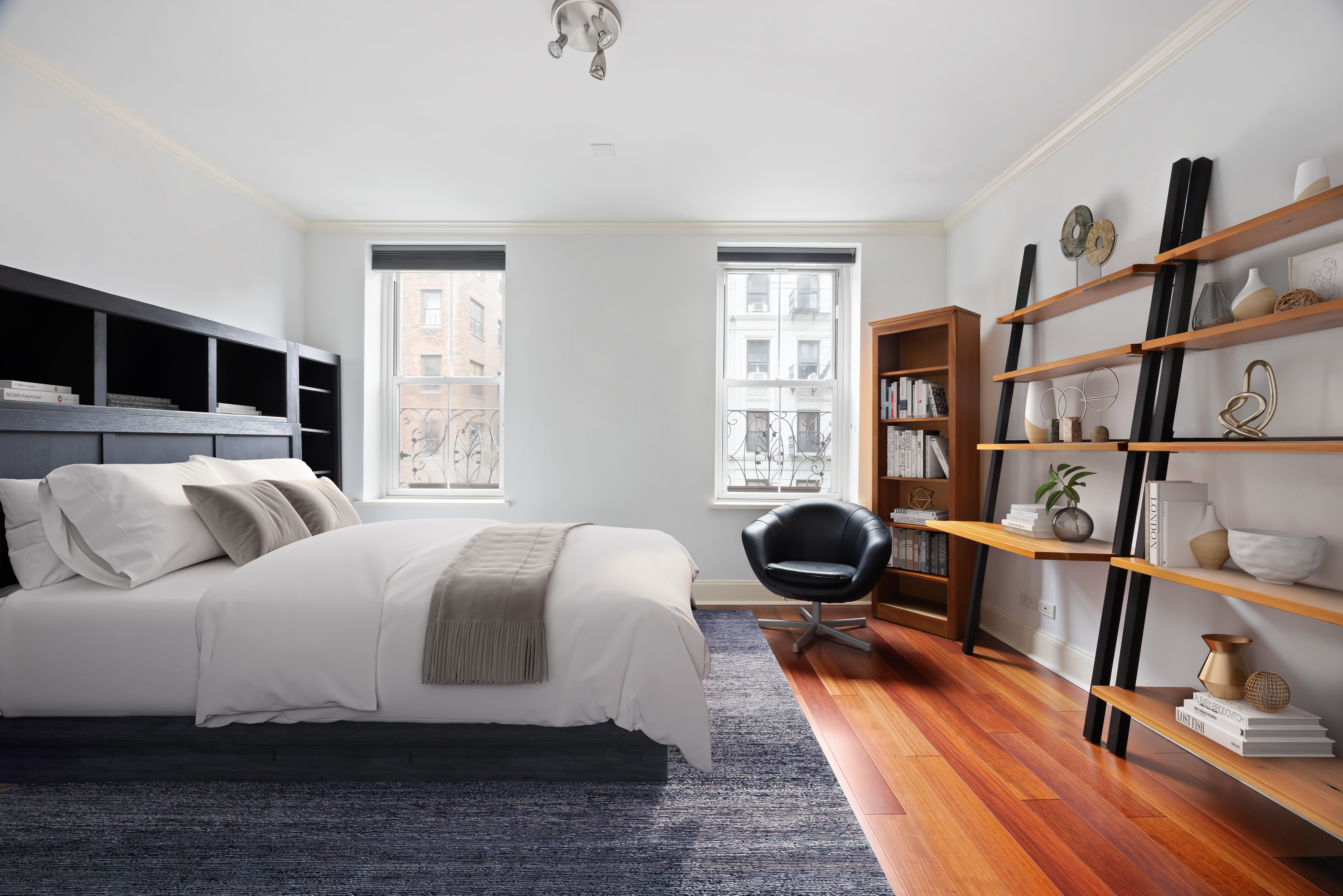 217 West 22nd Street Manhattan, NY 10011 - Photo 12 of 16 a bedroom with a bed a large window and book shelf