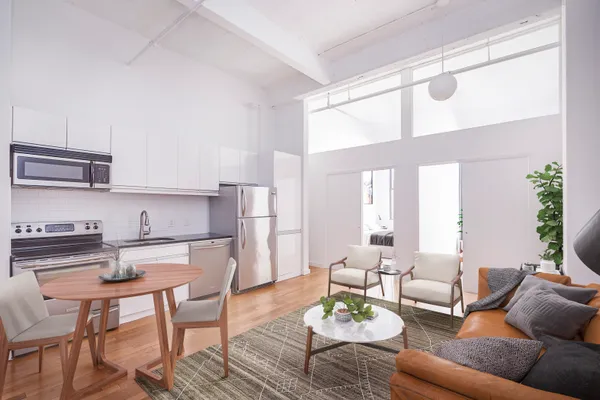 a living room with furniture wooden floor and a large window