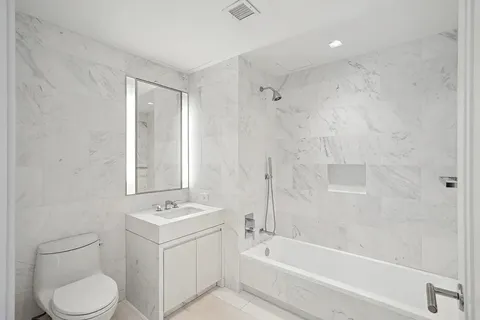 a bathroom with a sink toilet a vanity and bathtub