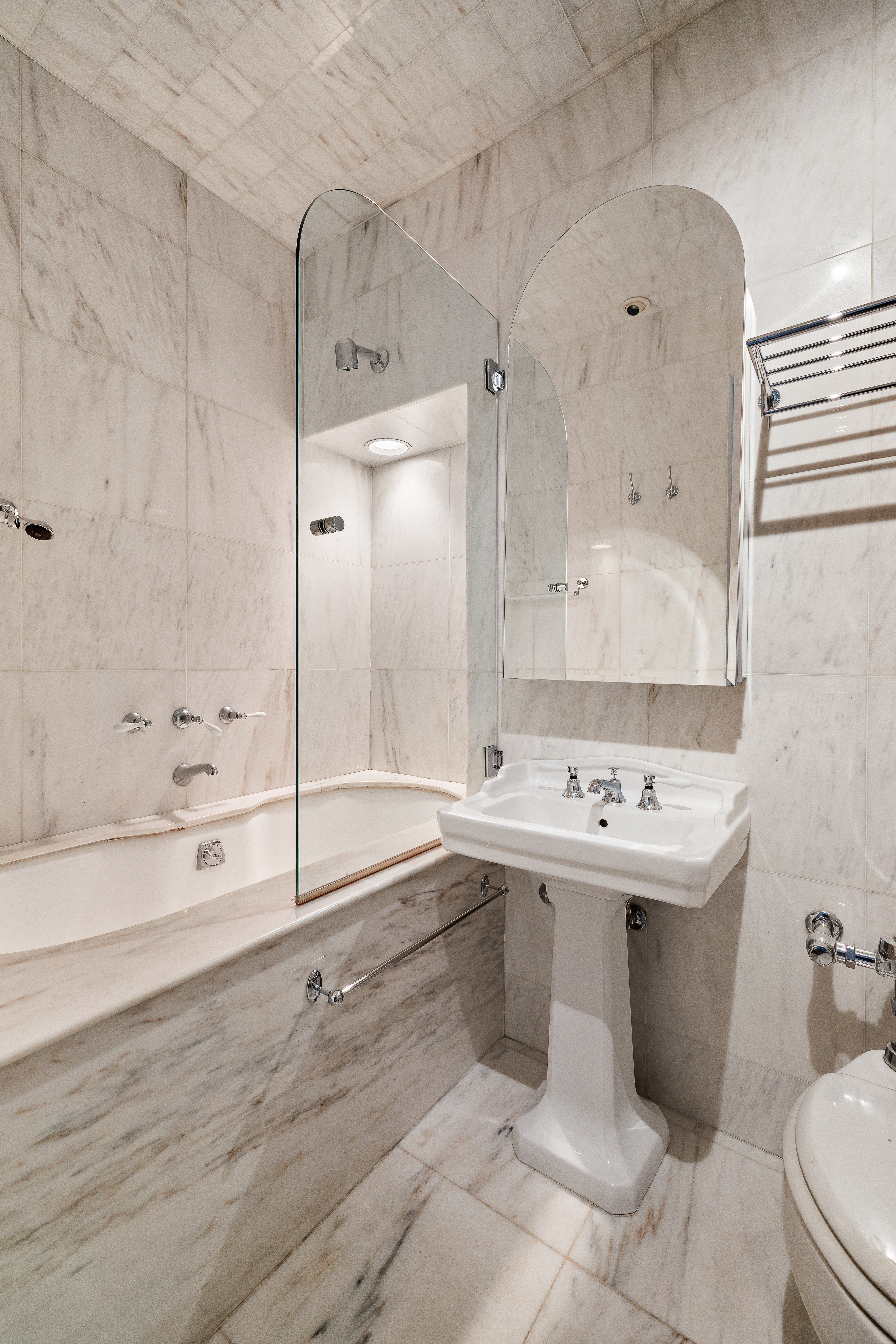 4 East 82nd Street, Unit 3F Manhattan, NY 10028 - Photo 8 of 9 a bathroom with a sink a toilet and shower