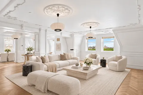 a living room with furniture chandelier and a window