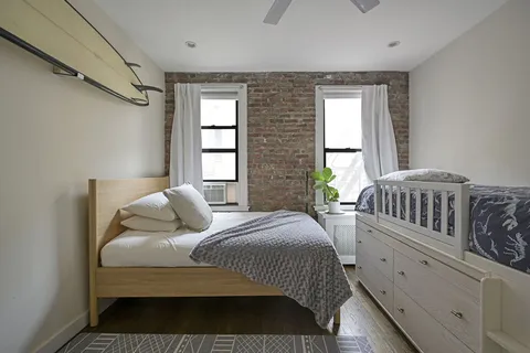 a bedroom with two beds and a window