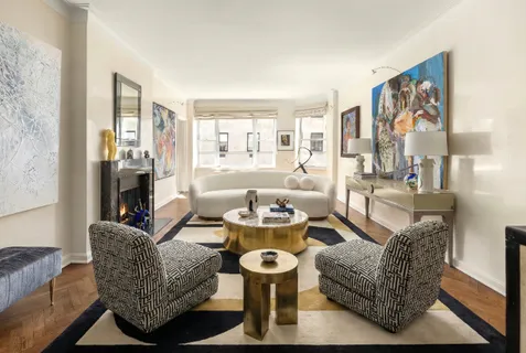 a living room with fireplace furniture and a large window