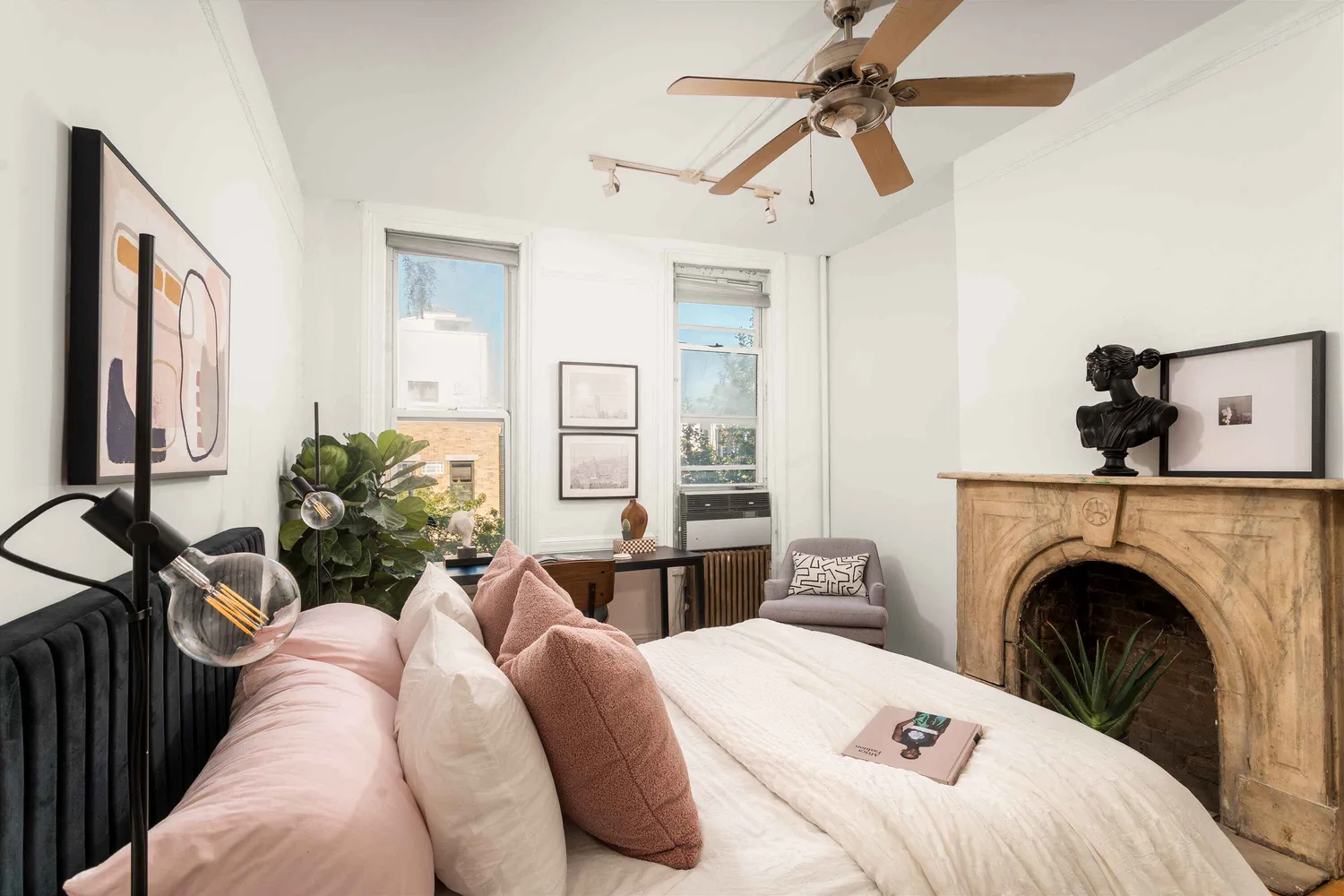 a bedroom with a bed a couch and potted plant