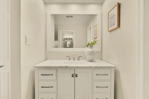 a bathroom with a sink vanity mirror and toilet