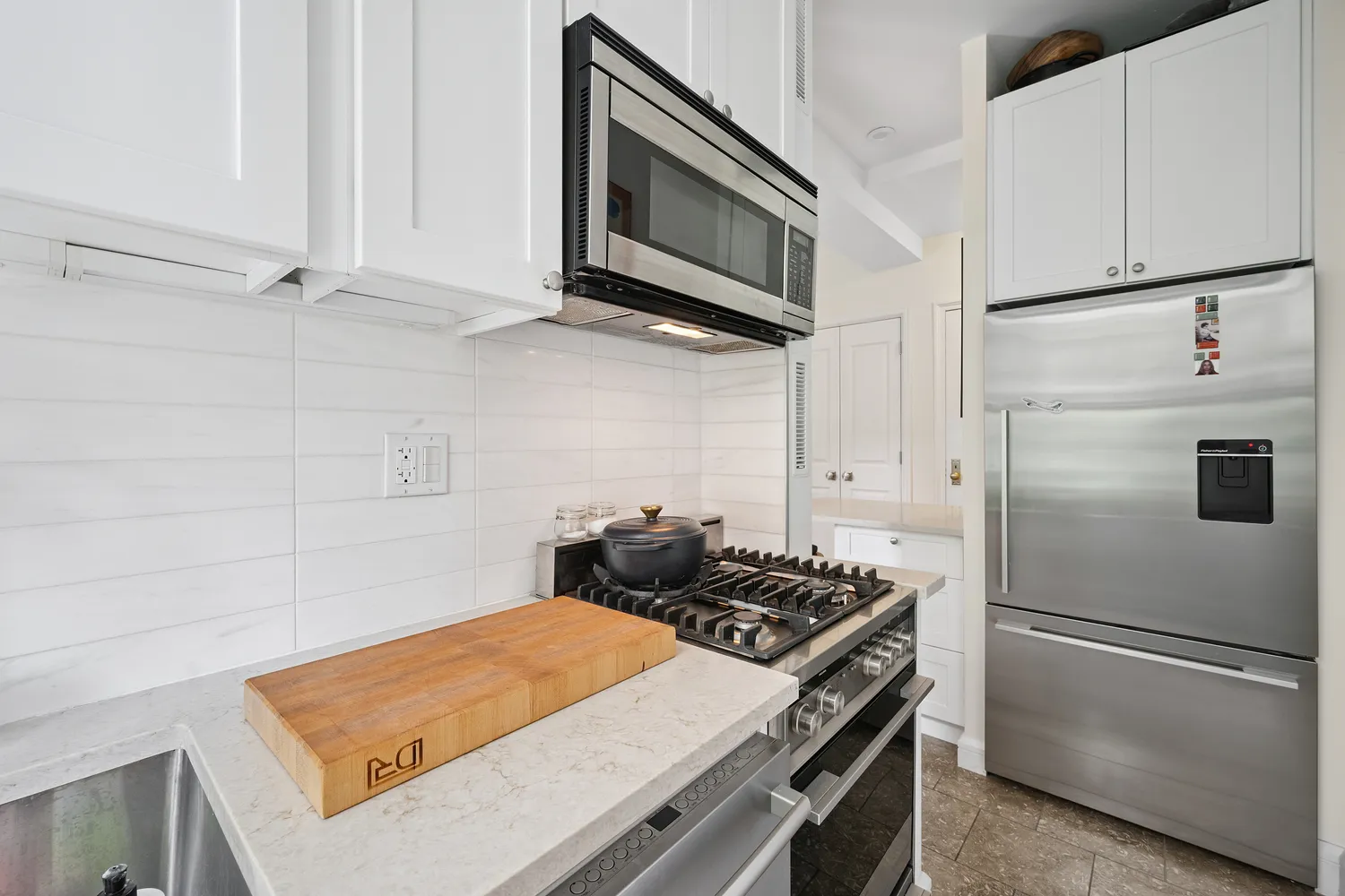 a kitchen with stainless steel appliances a refrigerator stove and microwave