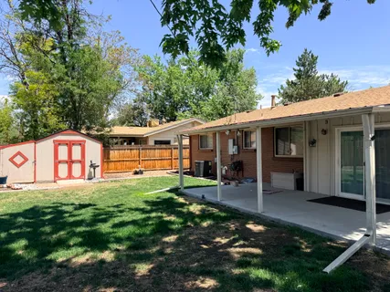 a view of a house with backyard and sitting area