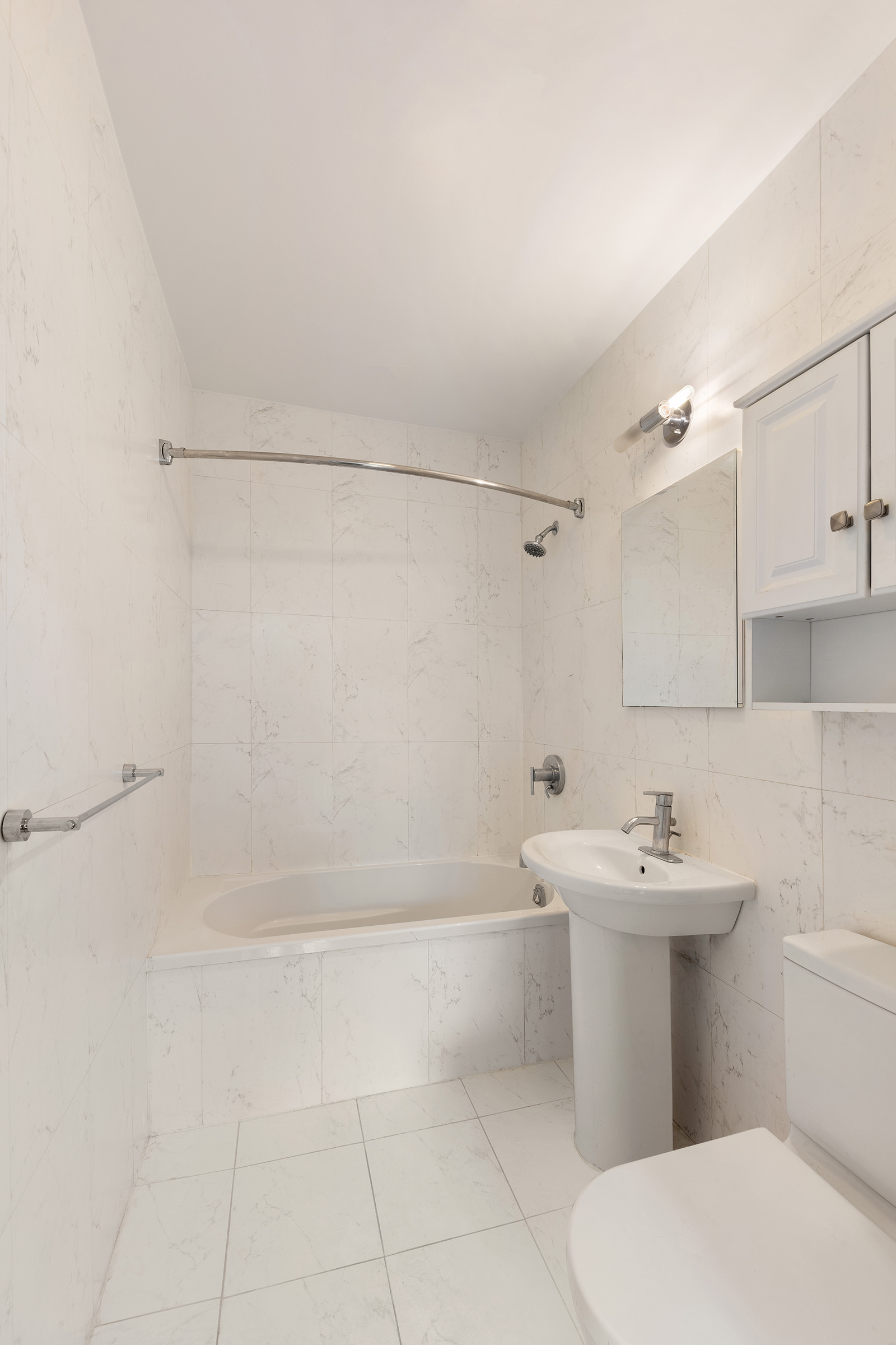 555 Lenox Avenue, Unit 3F Manhattan, NY 10030 - Photo 5 of 10 a bathroom with a sink a toilet and shower