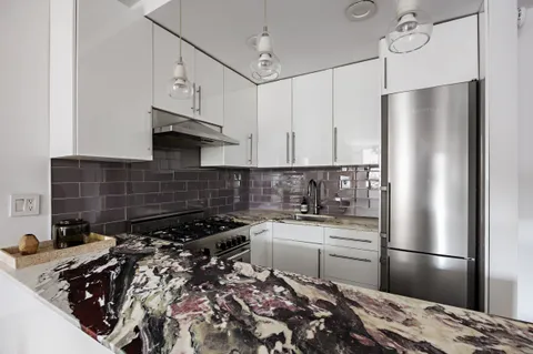 a kitchen with a refrigerator and a stove top oven
