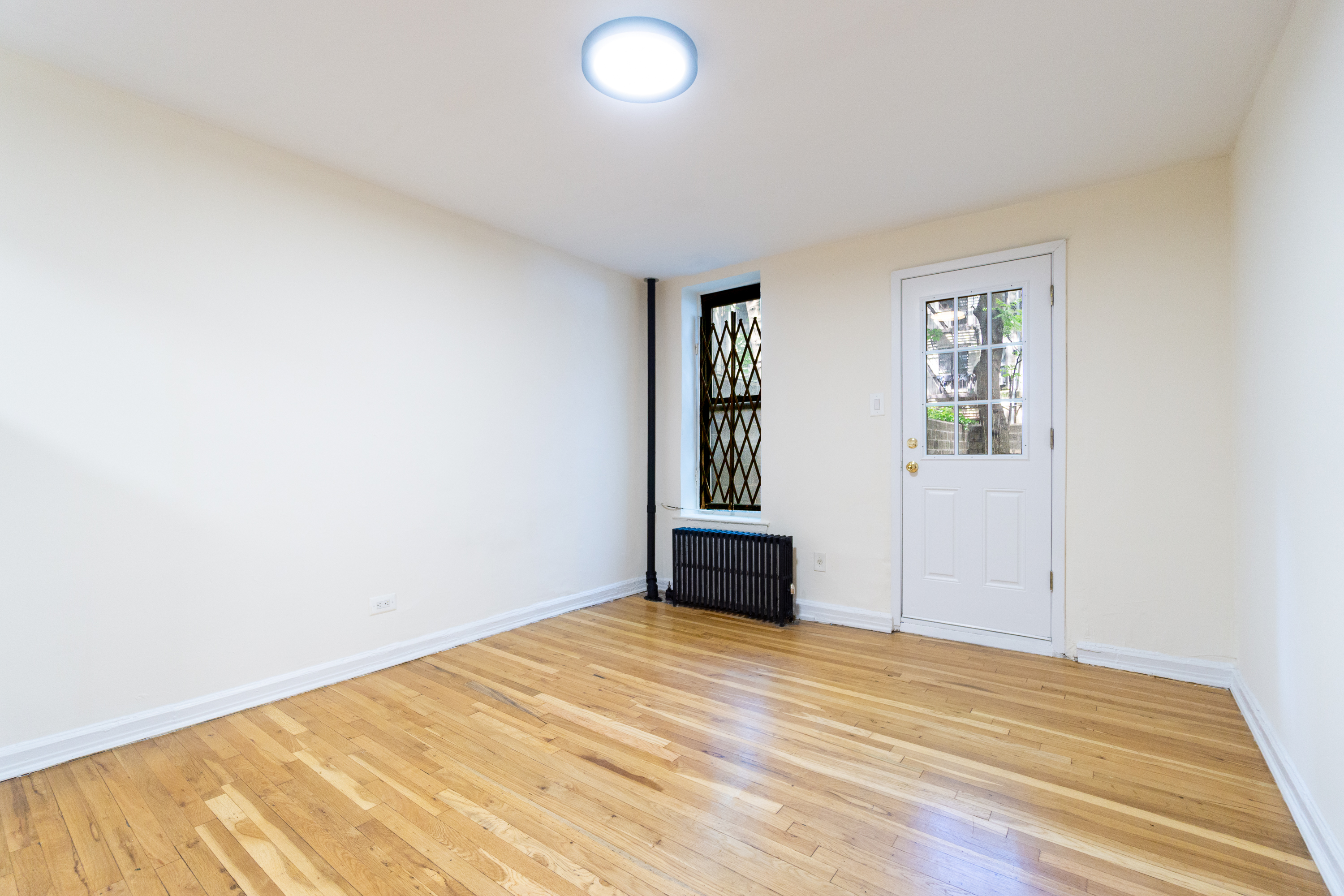 319 East 5th Street, Unit B Manhattan, NY 10003 - Photo 6 of 17 a view of empty room with wooden floor and fan