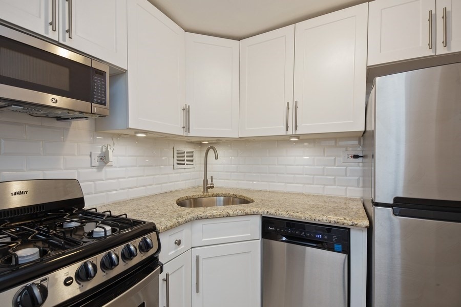 330 East 49th Street, Unit 11G Manhattan, NY 10017 - Photo 3 of 9 a kitchen with stainless steel appliances granite countertop a sink stove and refrigerator