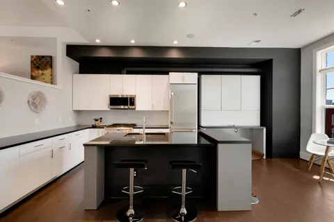 a kitchen with a sink a stove a microwave a counter top space and cabinets