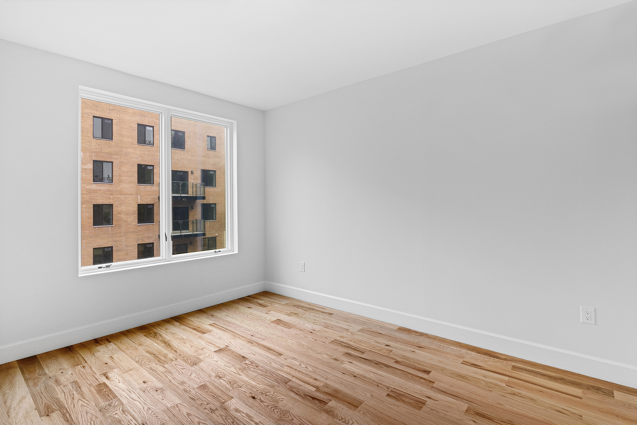 1098 Madison Street, Unit 4B Brooklyn, NY 11221 - Photo 7 of 11 a view of an empty room with wooden floor and a window