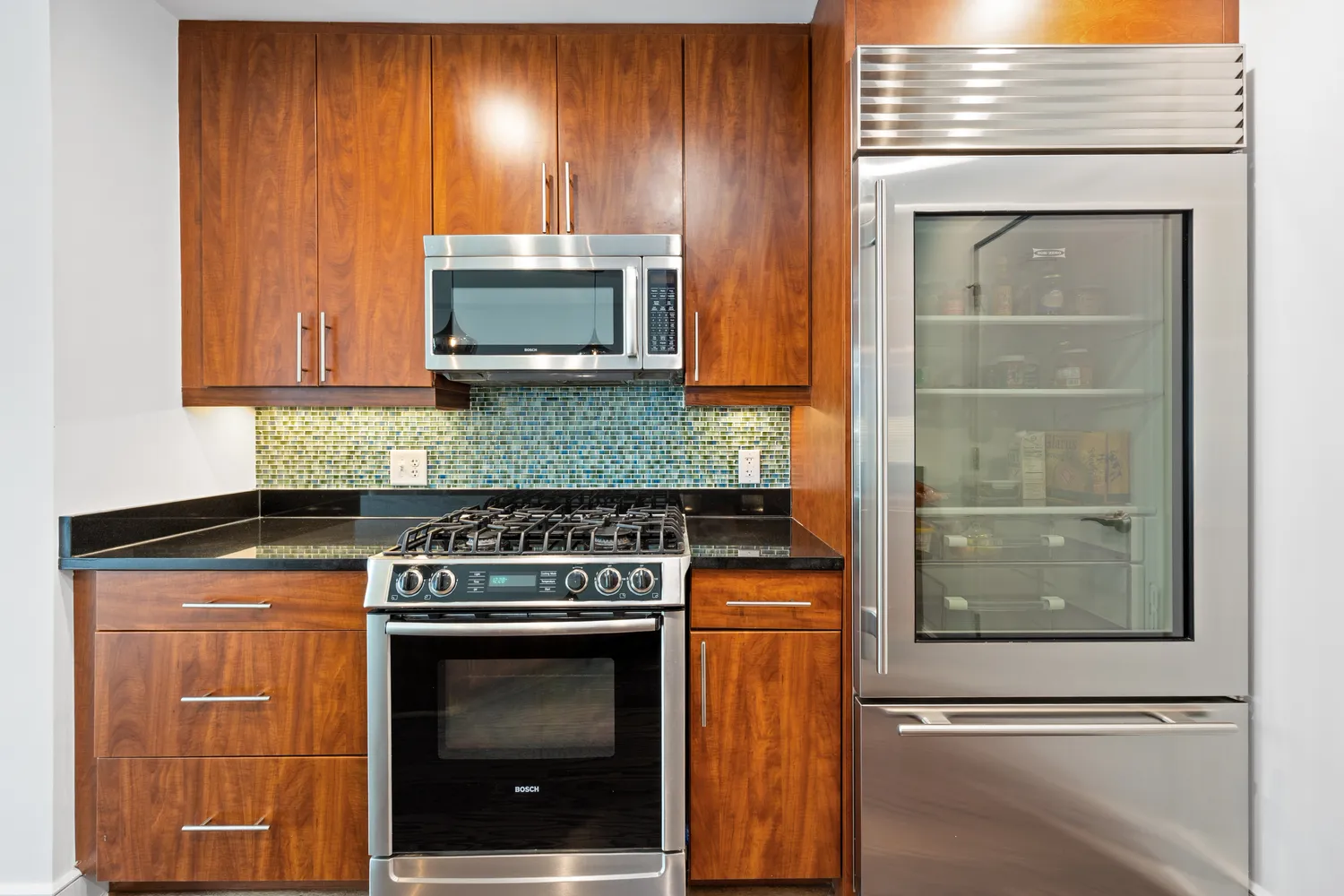 a kitchen with granite countertop wooden cabinets and a stove top oven