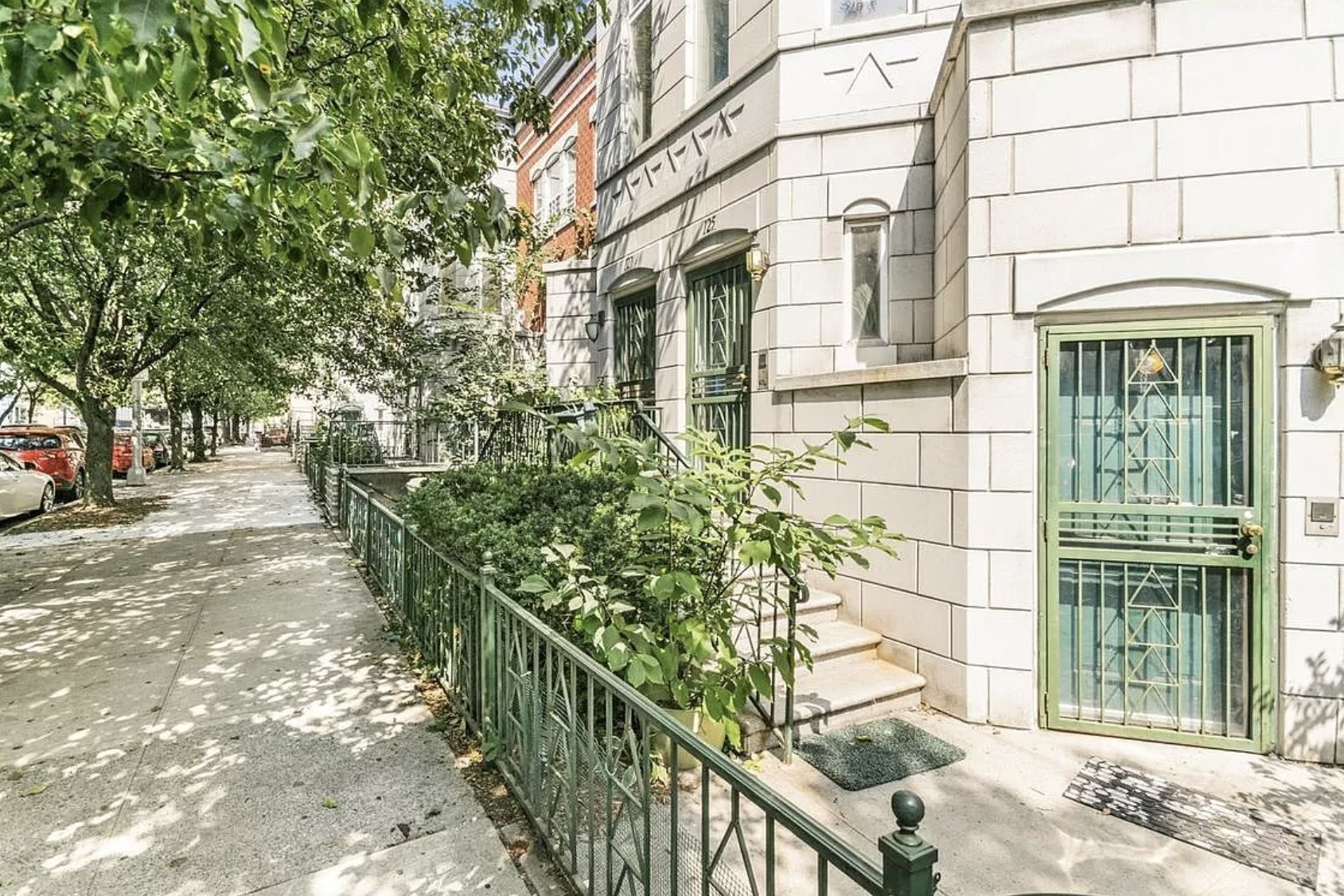 125 West 117th Street Manhattan, NY 10026 - Photo 22 of 23 a view of a brick house with large windows and a tree