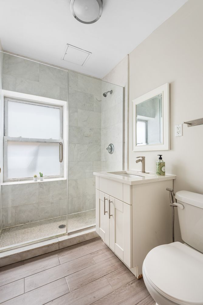 189 Woodpoint Road Brooklyn, NY 11211 - Photo 19 of 21 a bathroom with a sink a toilet and a mirror