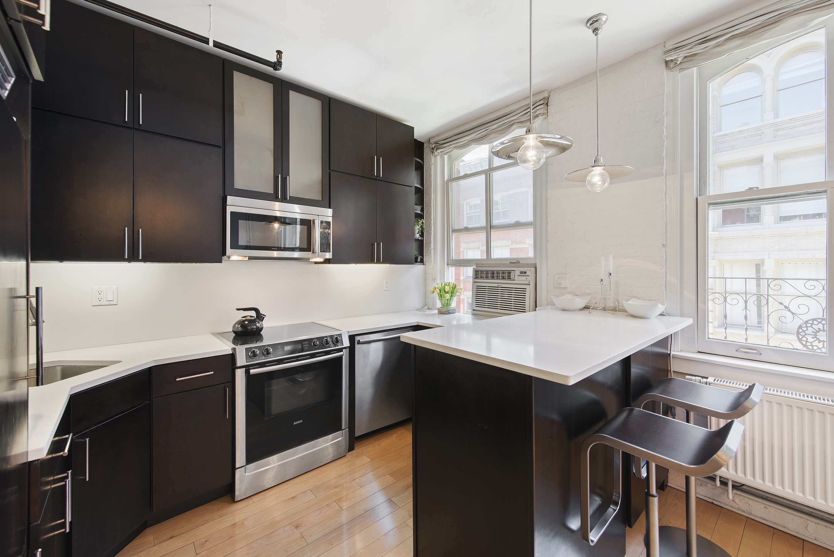 108 Wooster Street, Unit 5B Manhattan, NY 10012 - Photo 3 of 9 a kitchen that has a sink and a stove in it