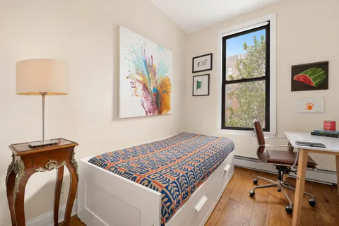 a bed sitting in a bedroom next to a window