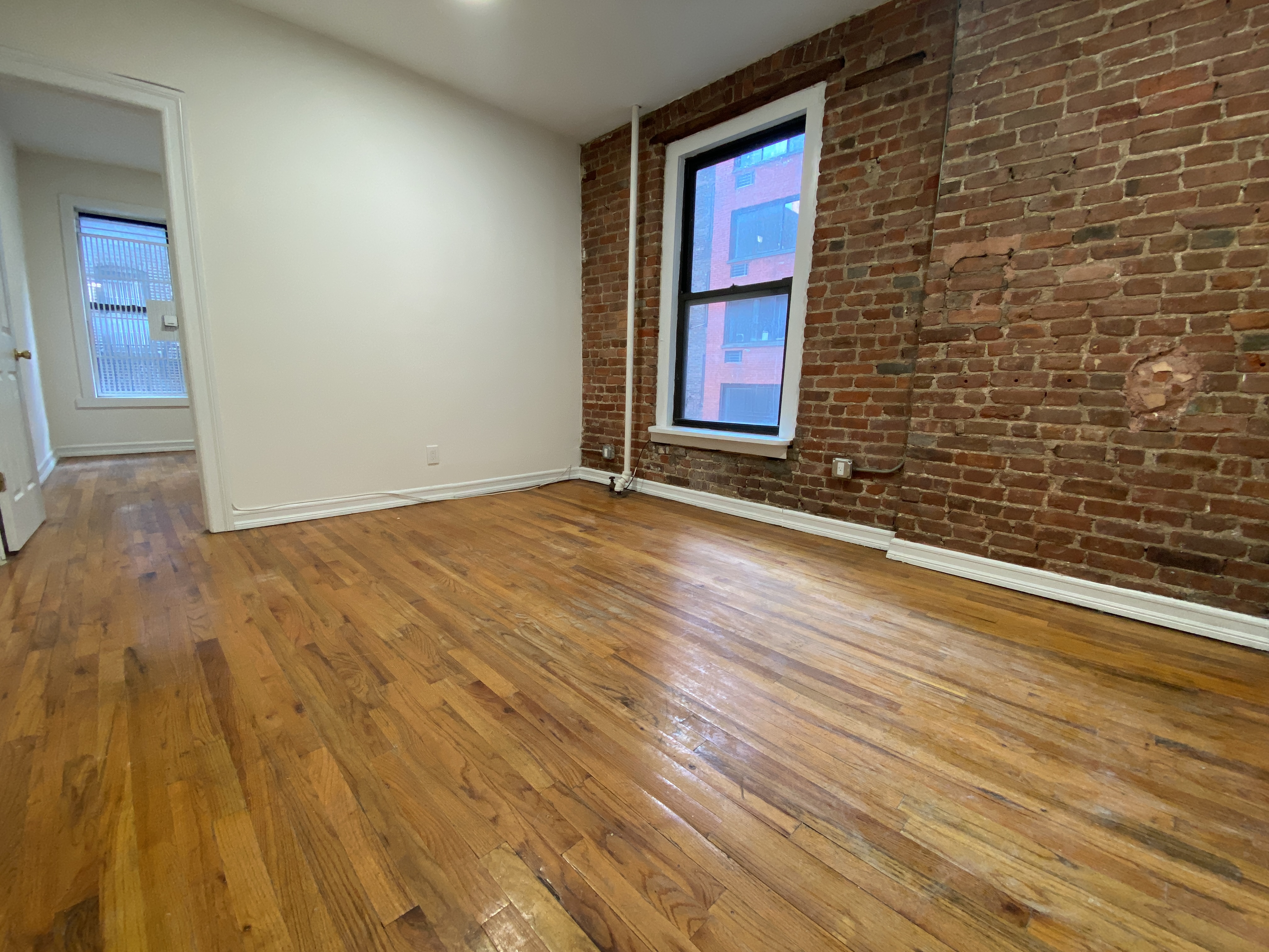 a view of an empty room with wooden floor