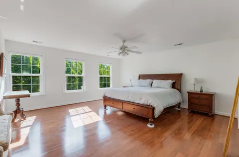 a bed sitting in a spacious bedroom next to a window