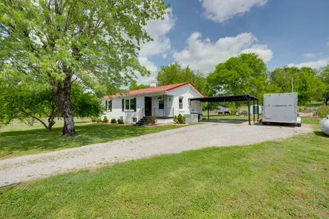 a front view of a house with yard and green space