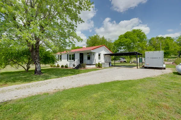 a front view of a house with yard and green space