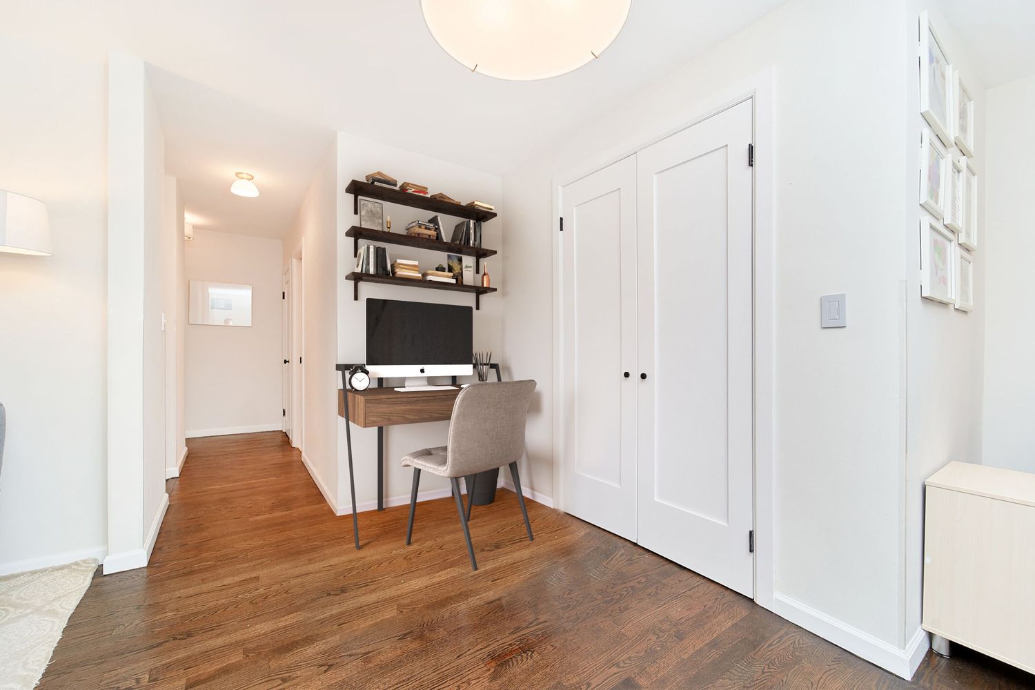 a view of a hallway with wooden floor and furniture