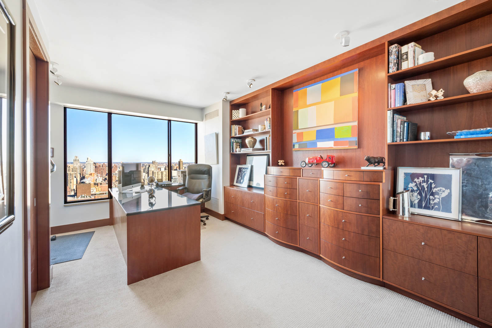 200 East 69th Street, Unit 44A Manhattan, NY 10021 - Photo 12 of 14 a living room with furniture a bookshelf and a large window