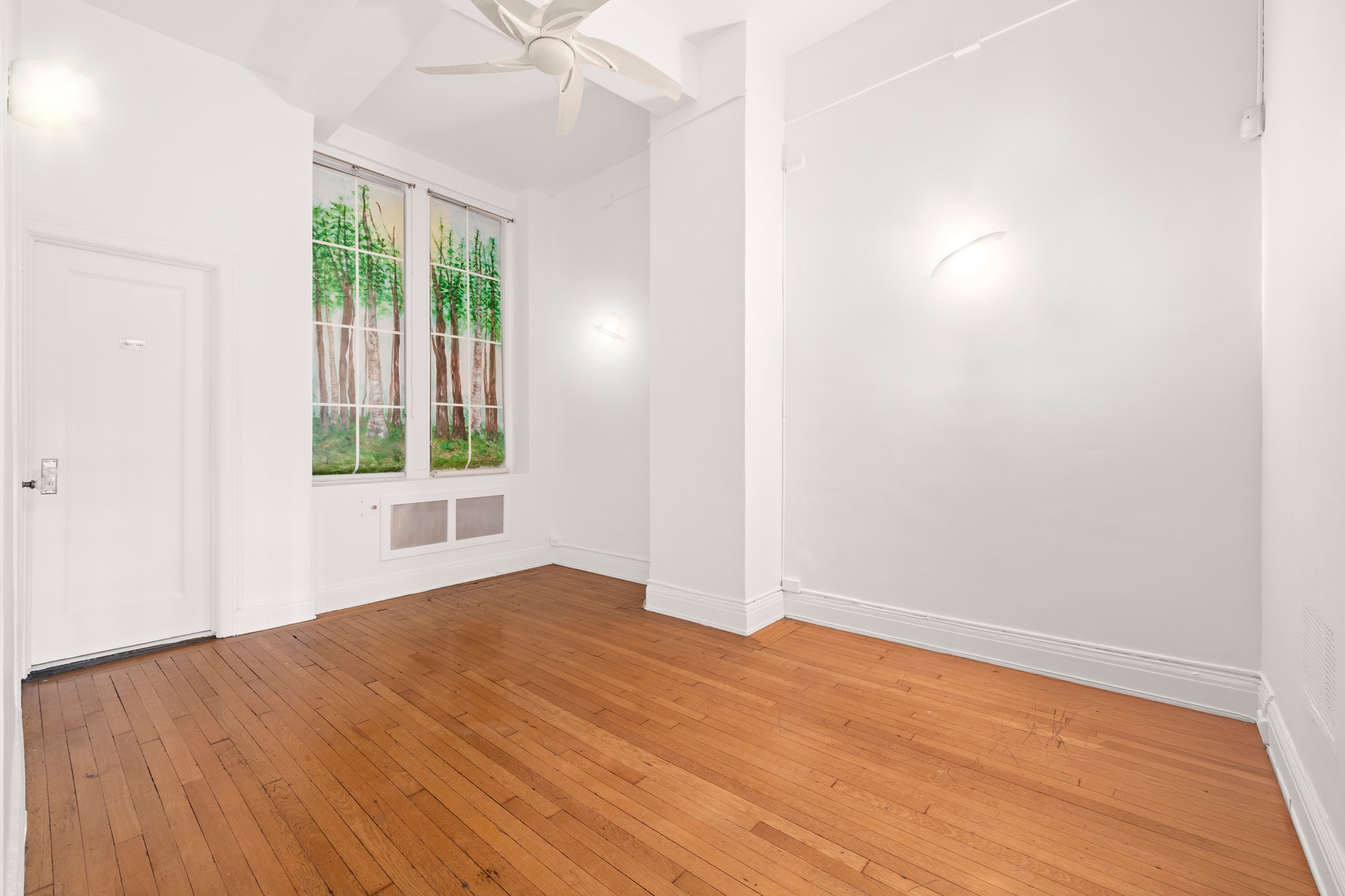 39 5th Avenue, Unit 1B Manhattan, NY 10003 - Photo 2 of 7 an empty room with wooden floor and windows
