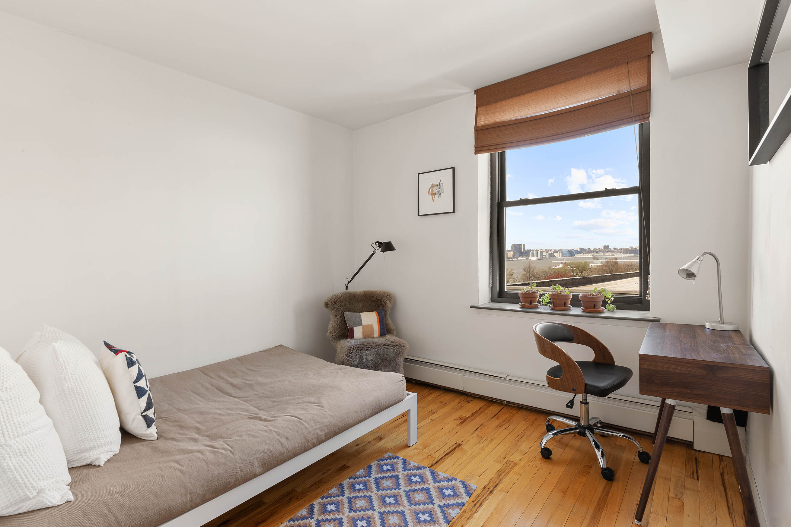 166 Bank Street, Unit 6B Manhattan, NY 10014 - Photo 10 of 16 a bedroom with a bed and a desk next to a window