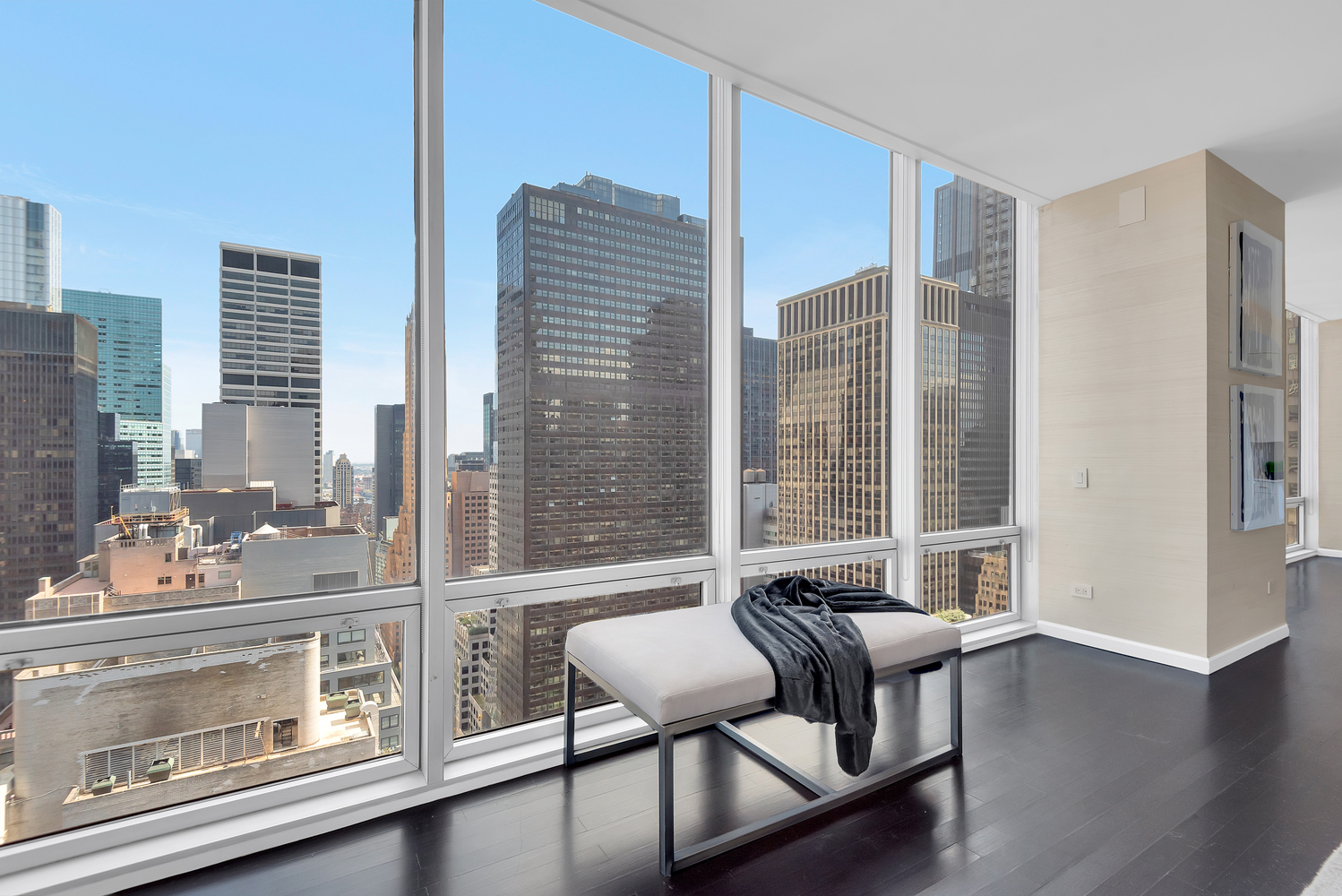 641 5th Avenue, Unit 26D Manhattan, NY 10022 - Photo 9 of 13 a living room with furniture and a floor to ceiling window