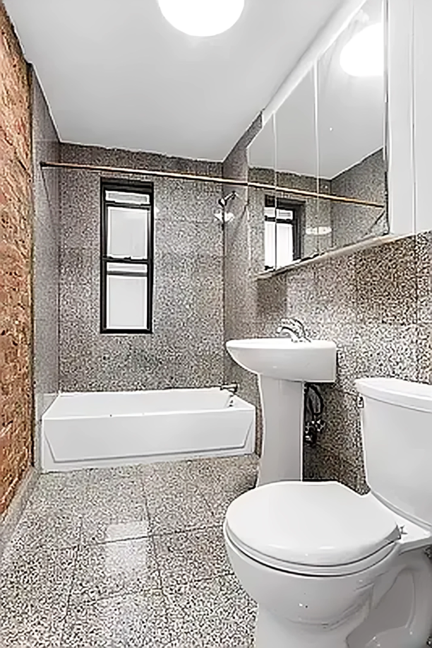 24 East 97th Street, Unit 22 Manhattan, NY 10128 - Photo 4 of 4 a bathroom with a toilet a sink and bathtub