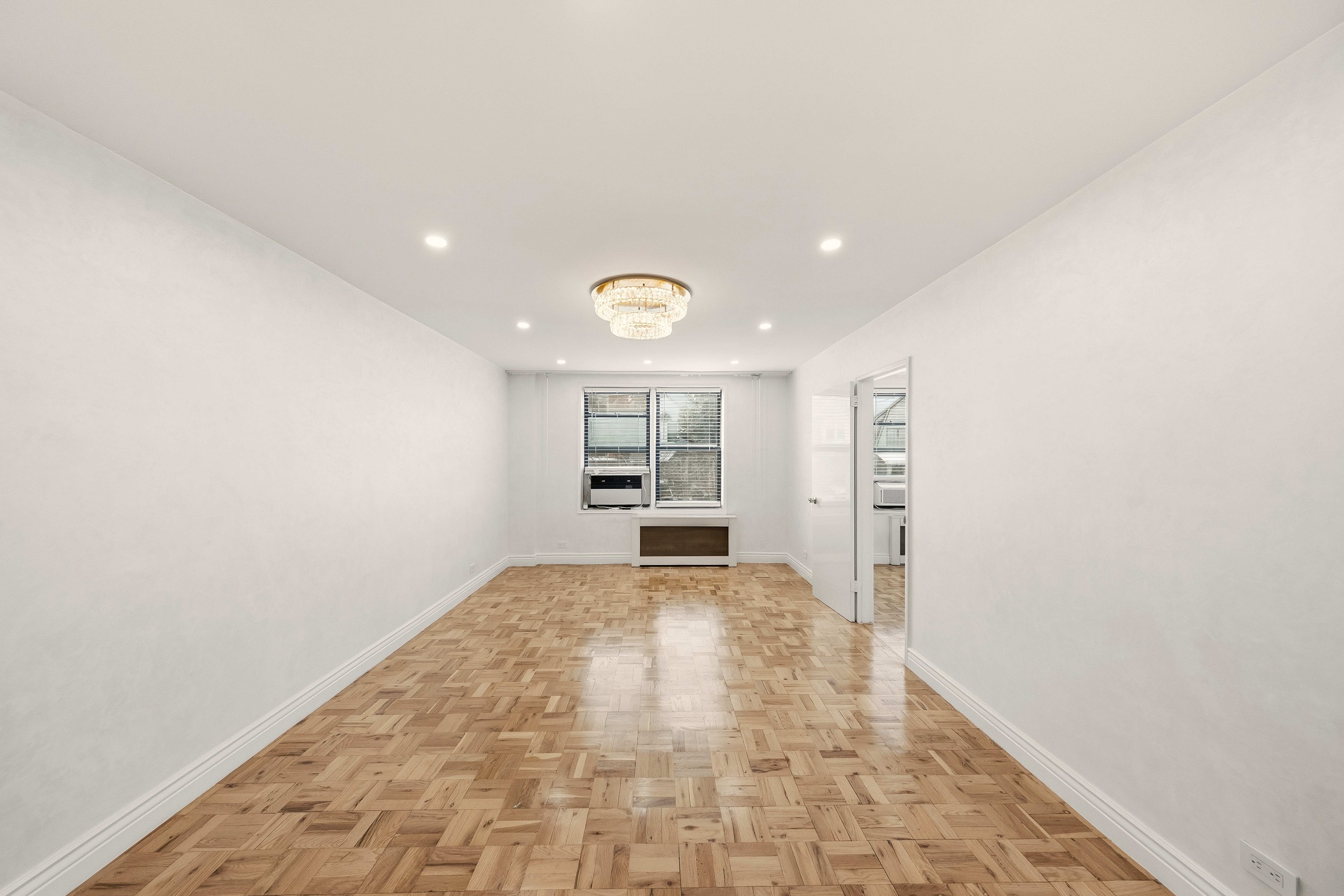 a view of empty room with kitchen and window