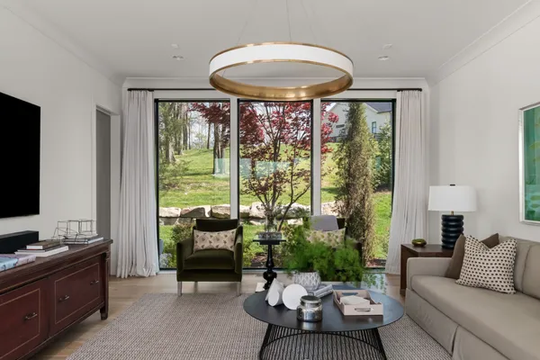 a living room with furniture a flat screen tv and a floor to ceiling window