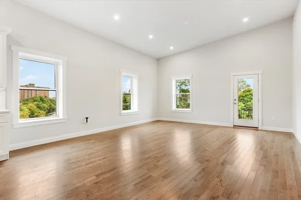 an empty room with wooden floor and window
