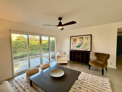a living room with furniture and a floor to ceiling window
