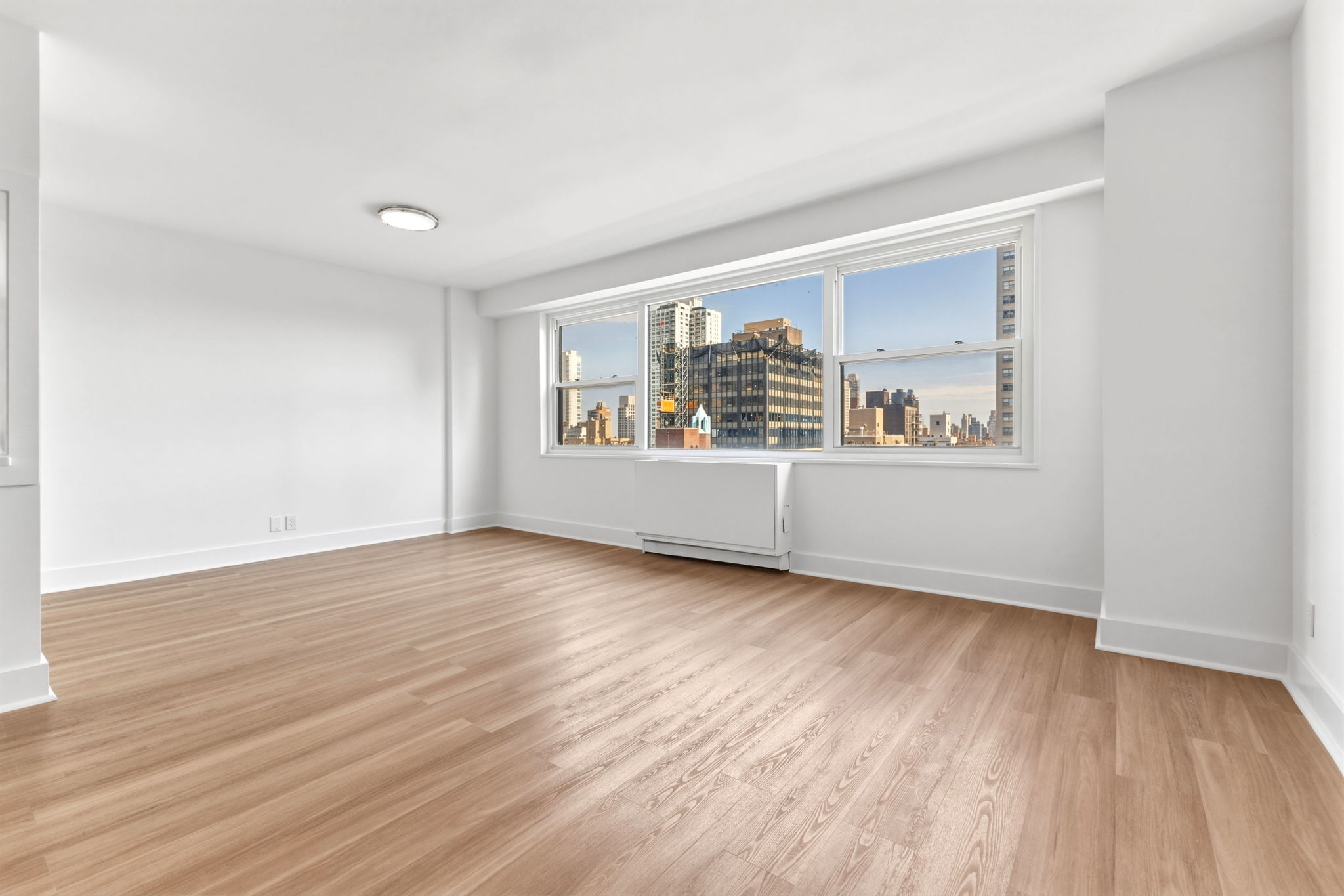 400 East 54th Street, Unit 24E Manhattan, NY 10022 - Photo 3 of 29 wooden floor in an empty room with a window