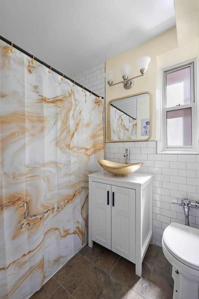 a bathroom with a granite countertop sink a toilet and shower