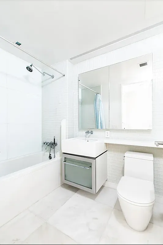 400 East 67th Street, Unit 7G Manhattan, NY 10065 - Photo 8 of 20 a bathroom with a sink a toilet and bathtub