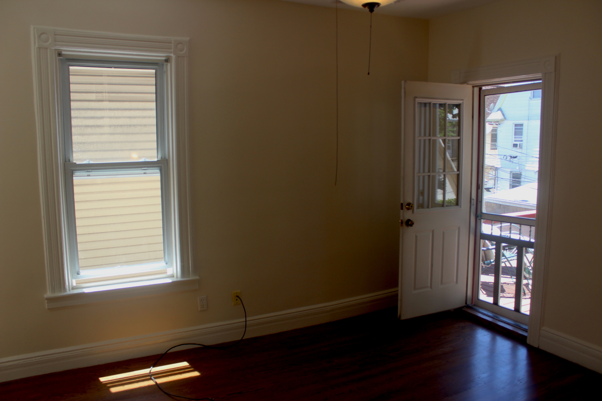310 East 4th Street, Unit 2 Brooklyn, NY 11218 - Photo 10 of 11 a view of an empty room with wooden floor and a window