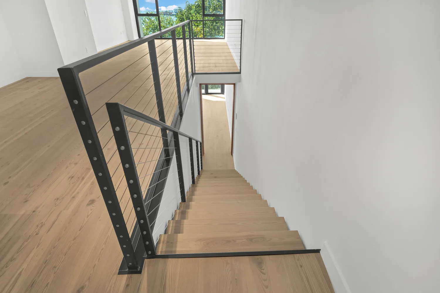 a view of an empty room with wooden floor and entryway