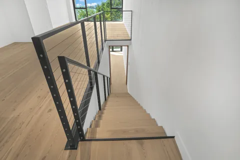 a view of an empty room with wooden floor and entryway