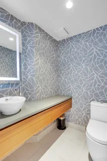 a bathroom with a granite countertop toilet and a sink