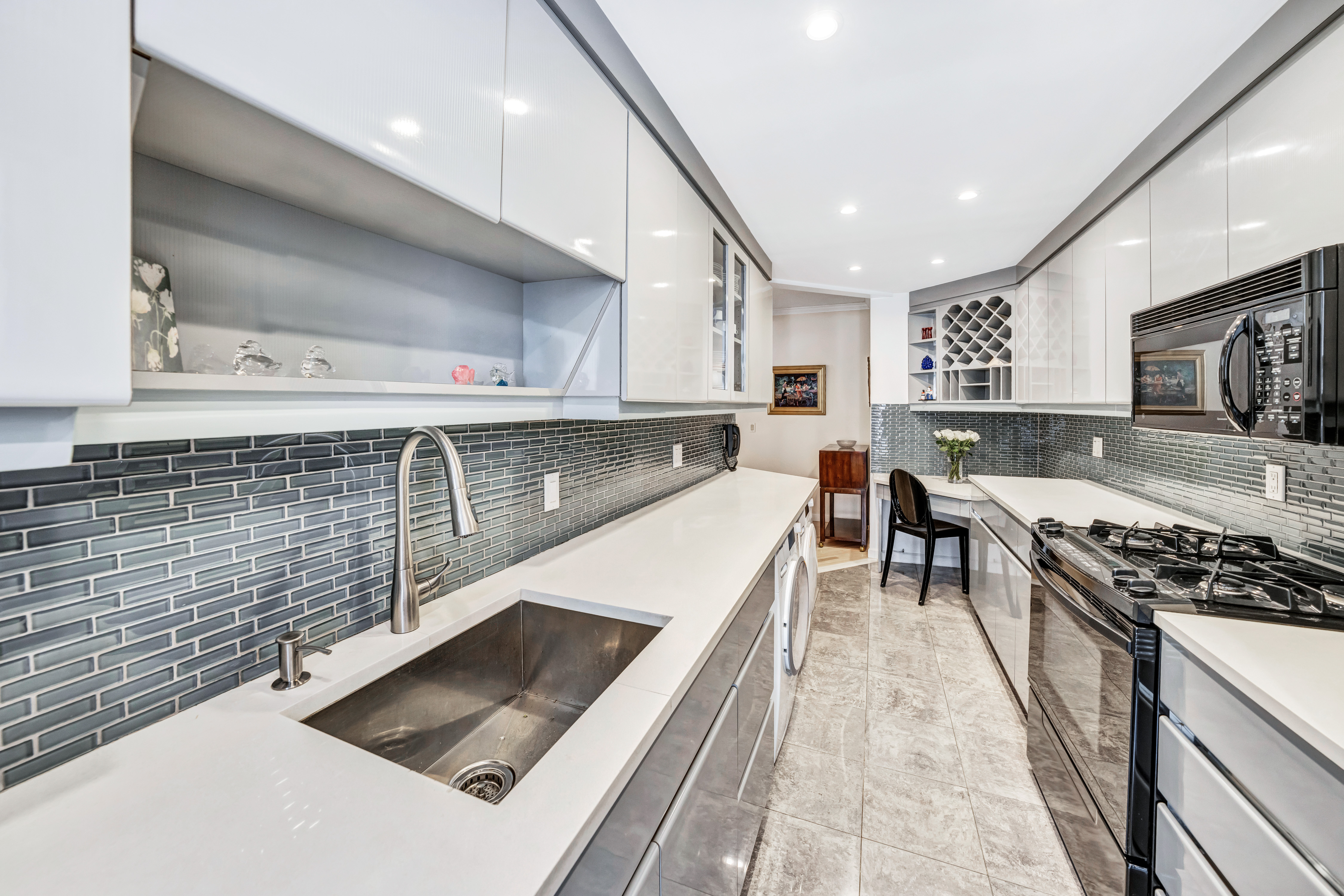 35 Sutton Place, Unit 7E Manhattan, NY 10022 - Photo 7 of 18 a large kitchen with stainless steel appliances a large counter top a stove and a sink