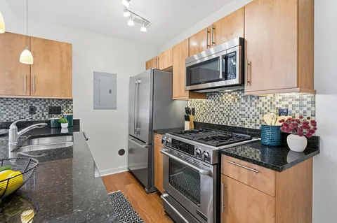 a kitchen with granite countertop a stove and a sink
