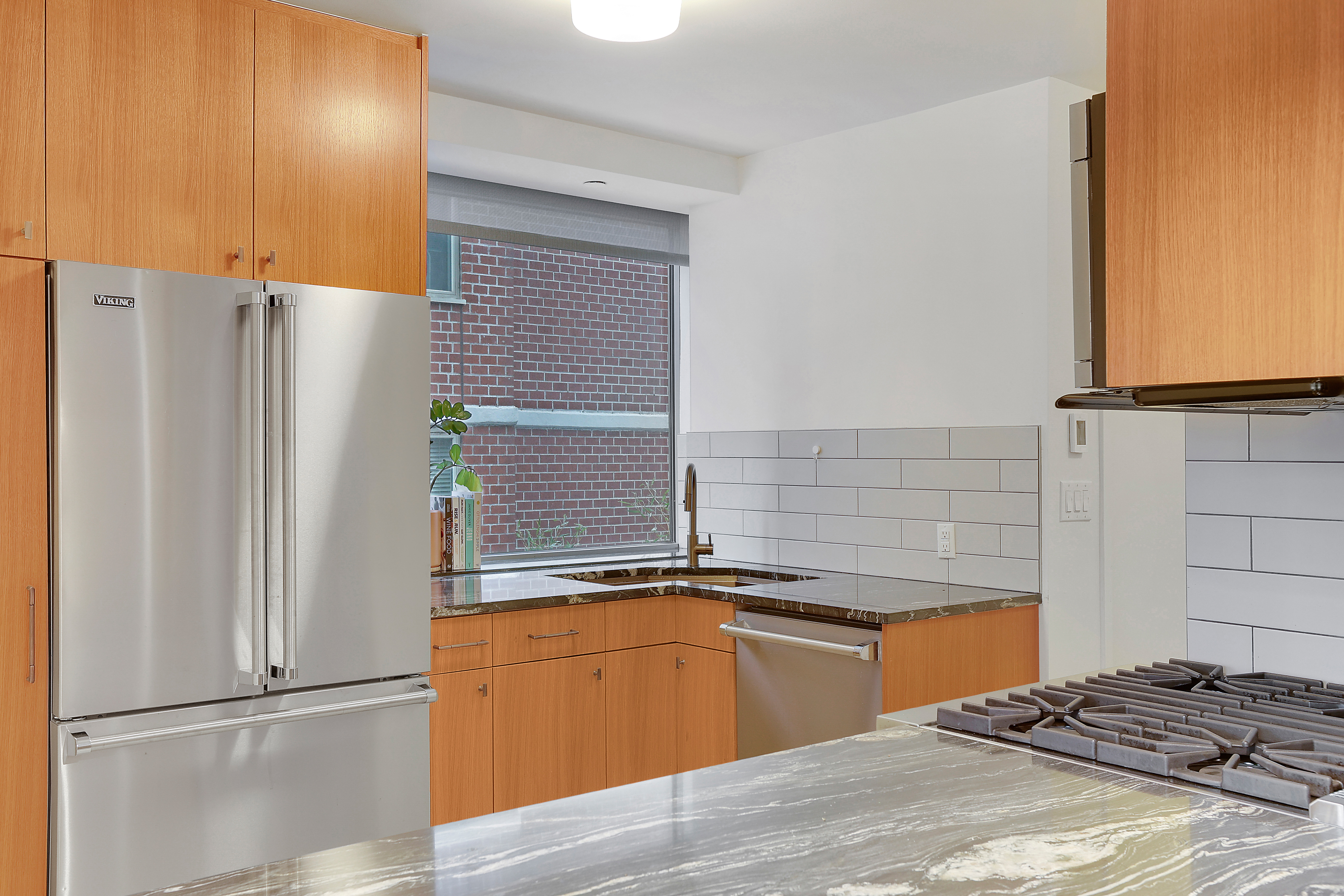 1965 Broadway, Unit 14H Manhattan, NY 10023 - Photo 6 of 10 a kitchen with stainless steel appliances granite countertop a refrigerator and a sink