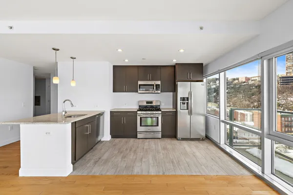 a large kitchen with stainless steel appliances and a large window