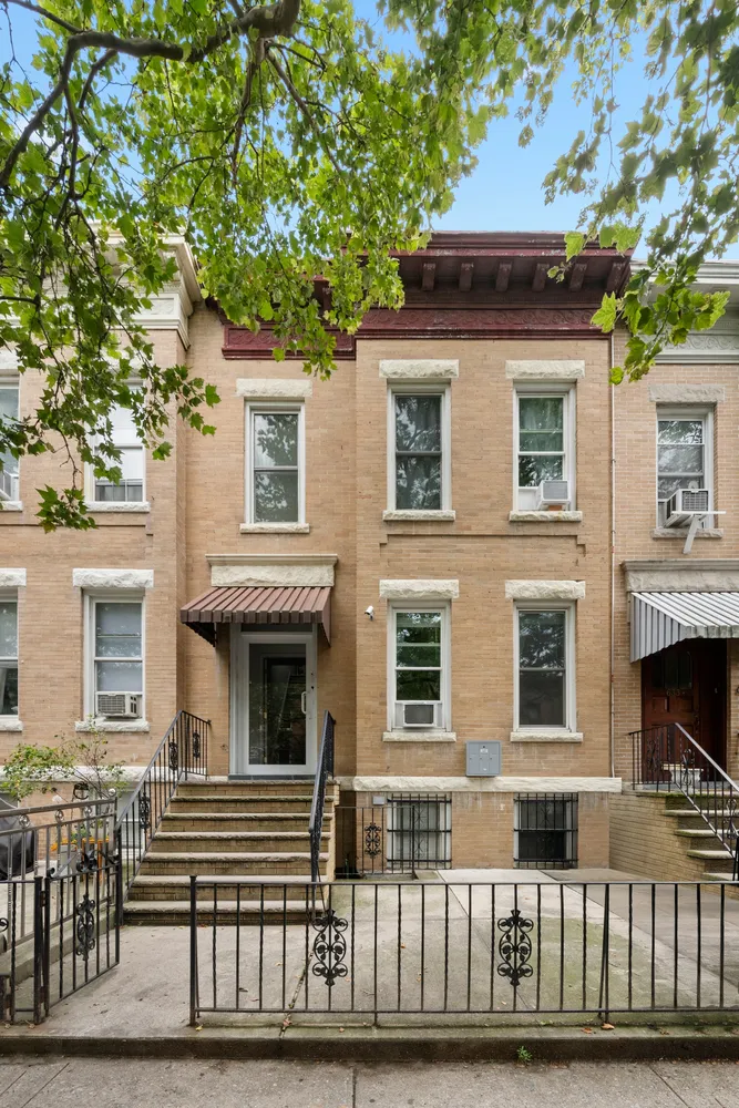 a front view of a house with a tree
