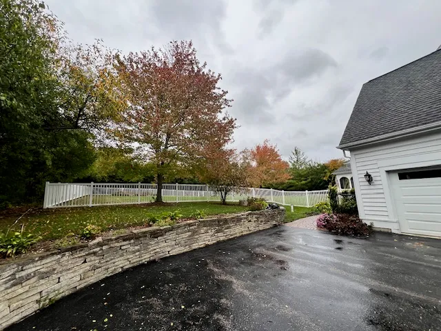 a white house with a big yard and large trees